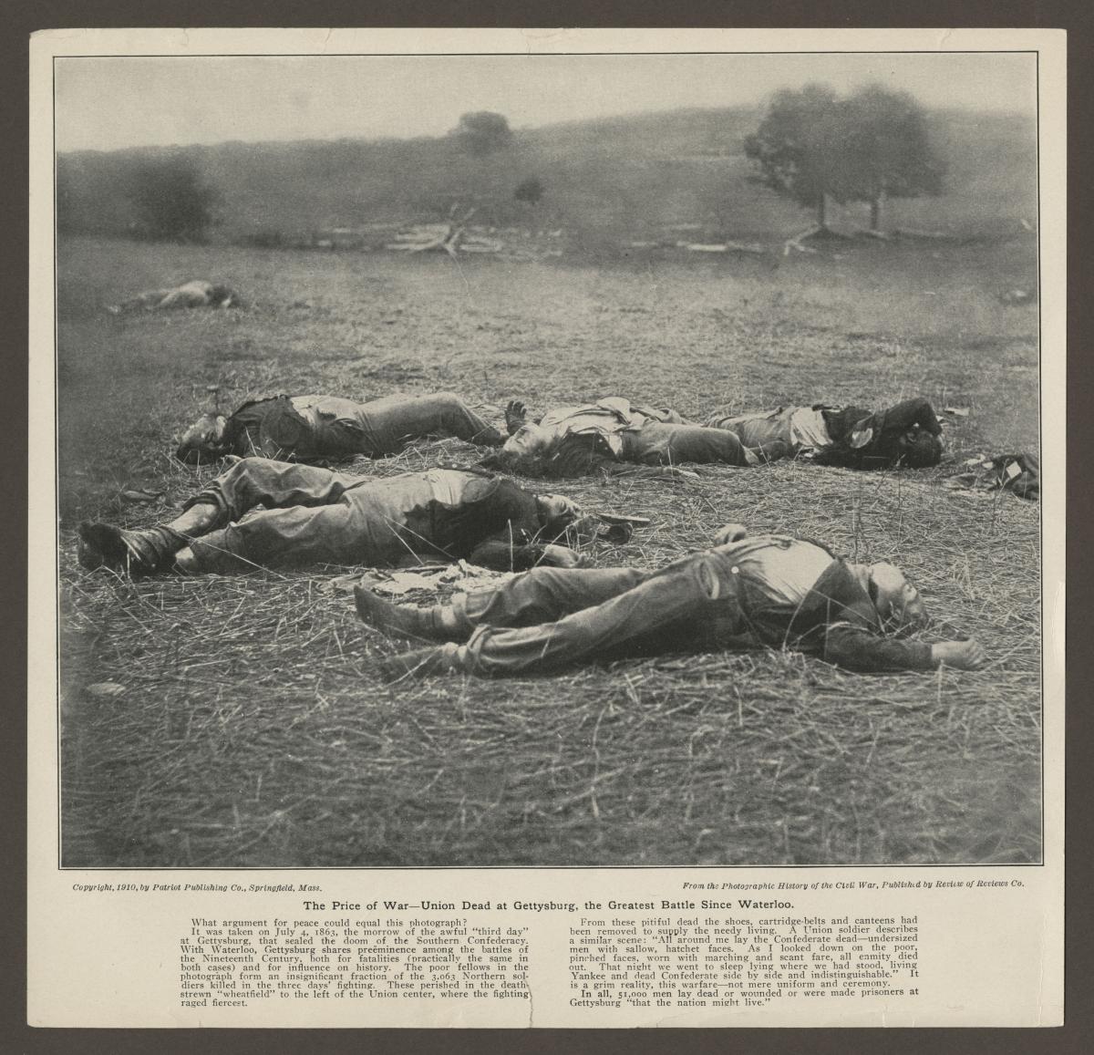Gettysburg Article With Brady Photo. B&W photograph shows a field with several clothed bodies lying in it. The photograph has been reproduced in a newspaper.